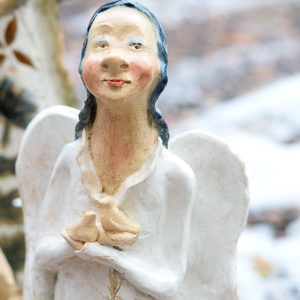 Biały anioł rzeźba ceramiczna. Ceramiczny anioł stojący w białym kolorze trzymający ptaszki wolności. Radosny, optymistyczny anioł.