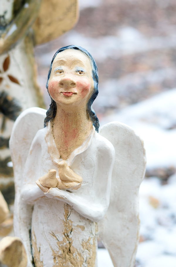 Biały anioł rzeźba ceramiczna. Ceramiczny anioł stojący w białym kolorze trzymający ptaszki wolności. Radosny, optymistyczny anioł.