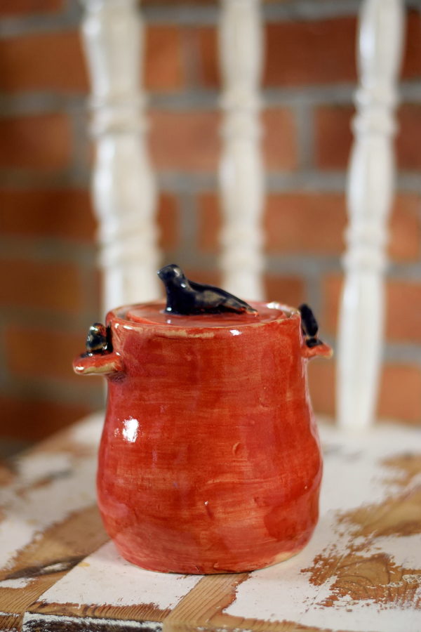 Ręcznie stworzony pojemnik na smalec. Ceramiczny garnuszek wykonany został z jasnej gliny. Pokryty został szkliwami do kontaktu z żywnością w kolorze czerwonym.