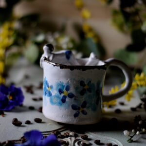 Ceramiczny kubek z motywem niebieskich kwiatków.