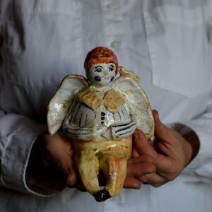 Figurka małego, pękatego aniołka z ptaszkiem.